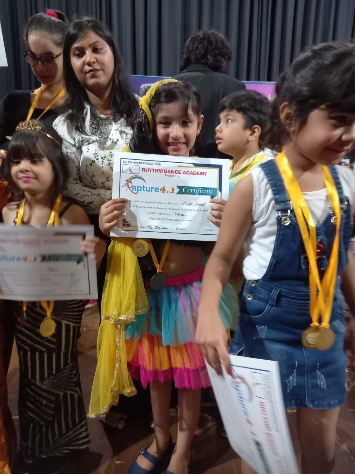 Junior dancers in costume holding their competition certificates