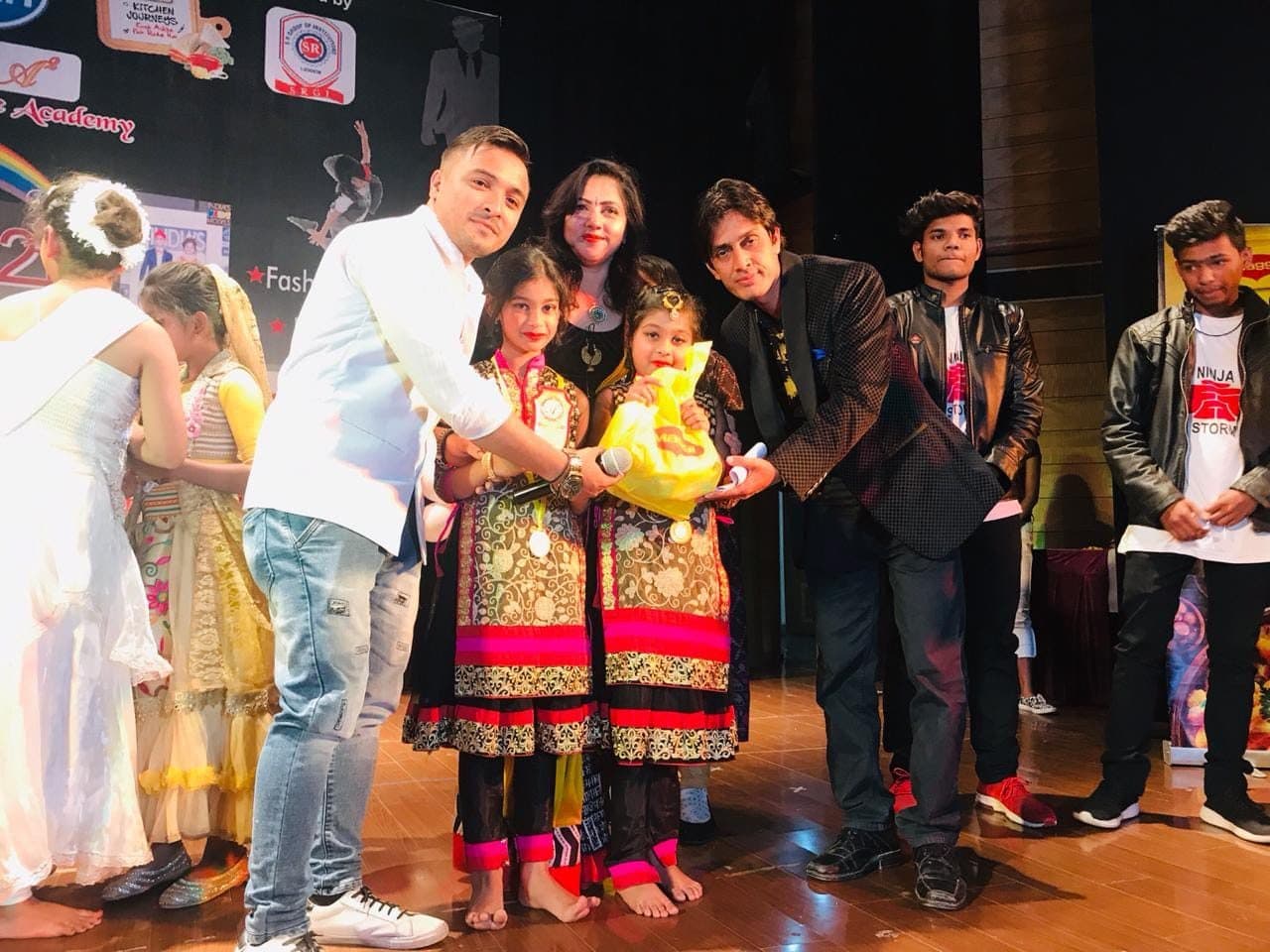 Young dancers receiving prizes from guests on stage
