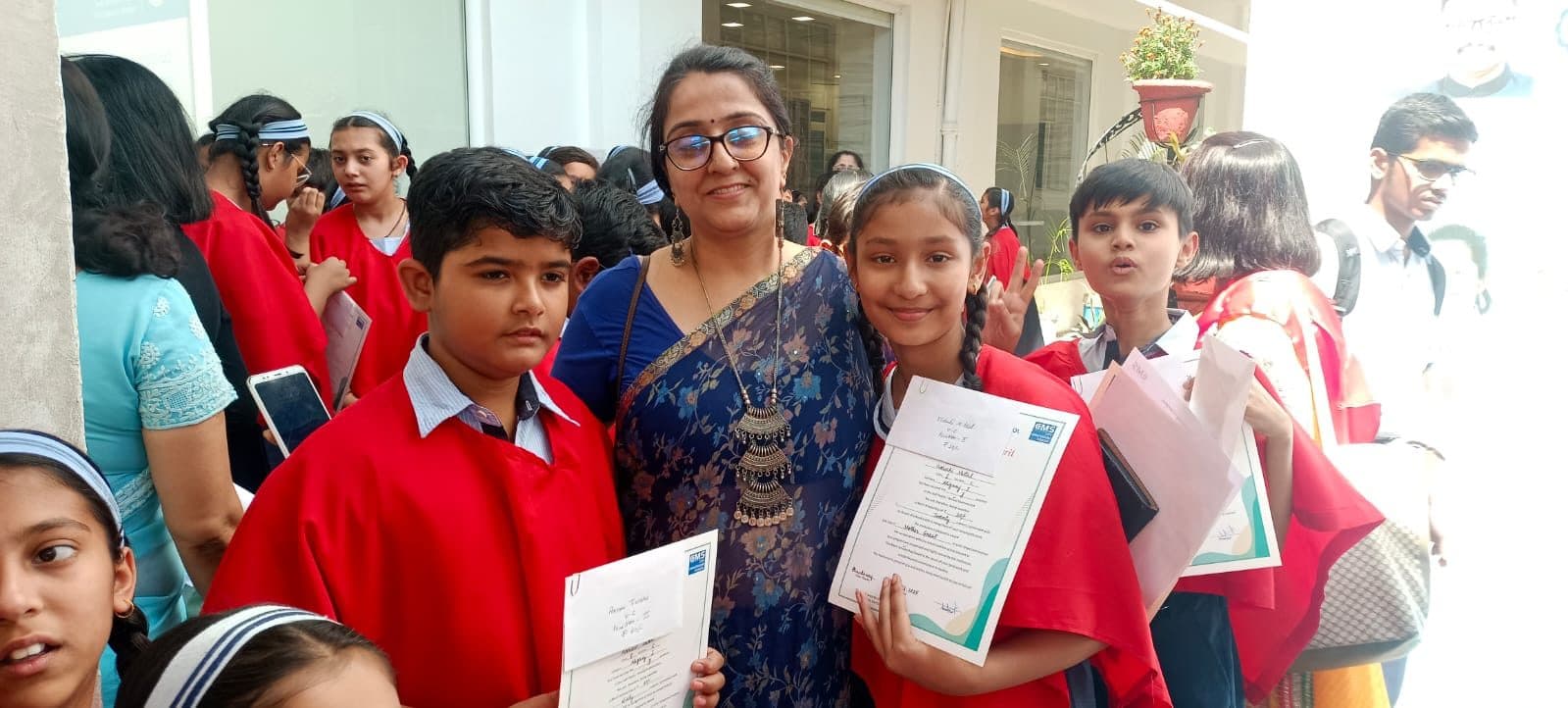 Teacher standing with students holding their achievement certificates