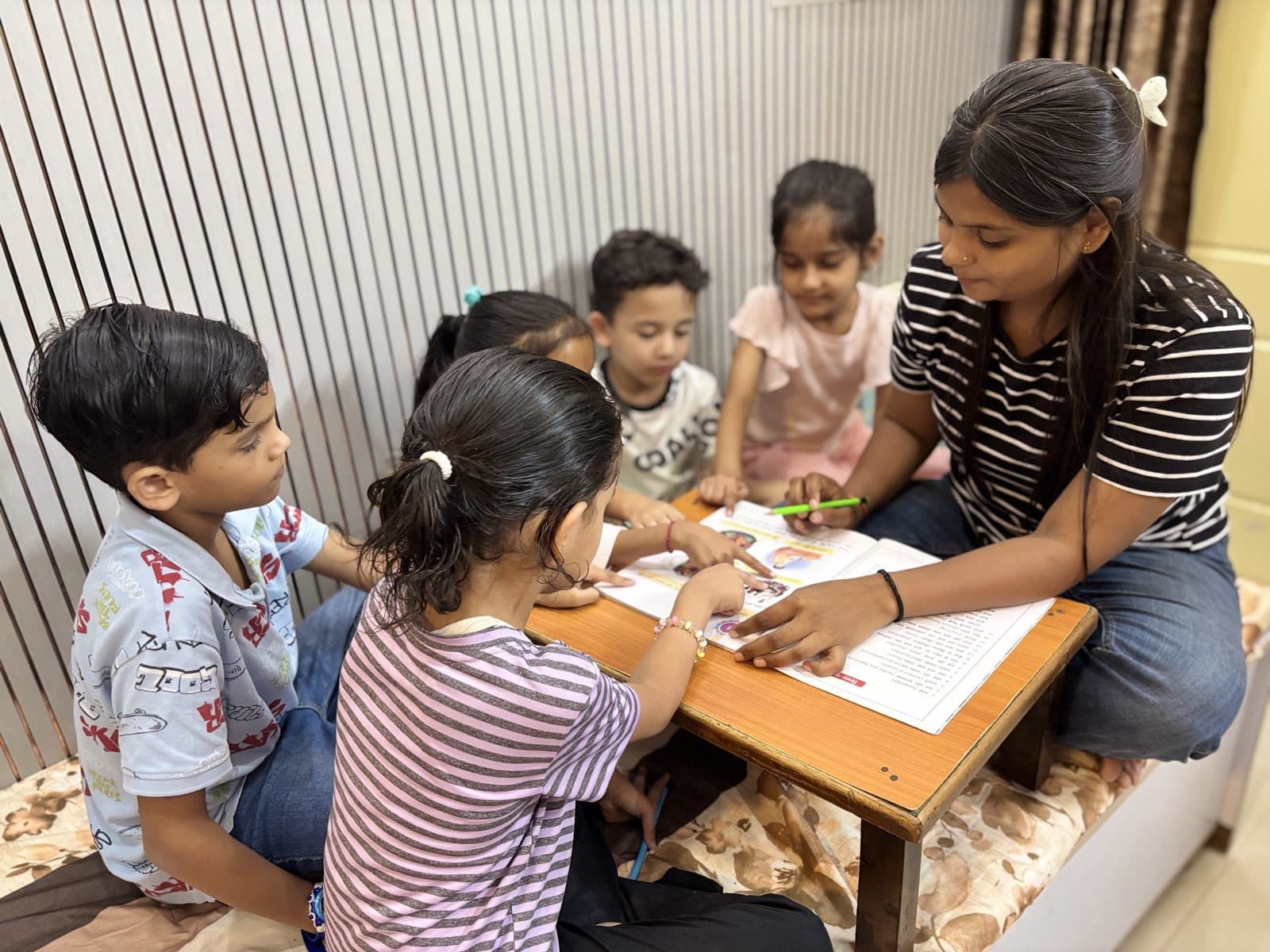 Students working through worksheets with their teacher in a small batch